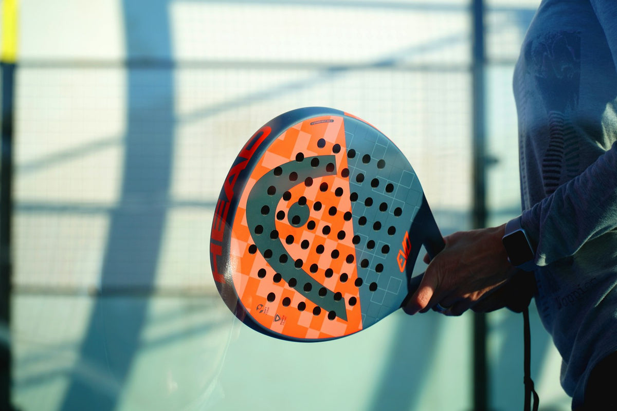 Stock placeholder: player holding an orange padel racket