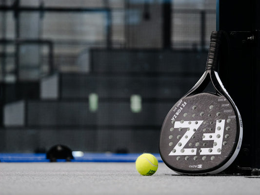 Stock placeholder: padel racket and ball on grey court